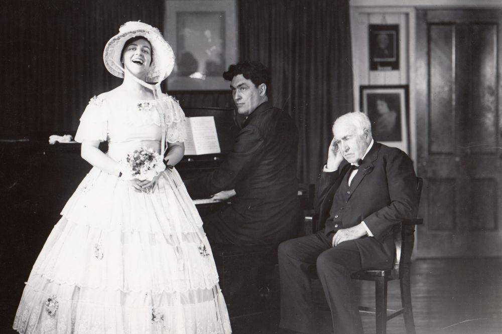 Thomas Edison (kanan) mendengarkan Helen Davis bernyanyi, Victor Young (bermain piano), di Ruang Musik Gedung 5 di Laboratorium West Orange Edison. (commons.wikimedia.org/U.S. National Park Service)