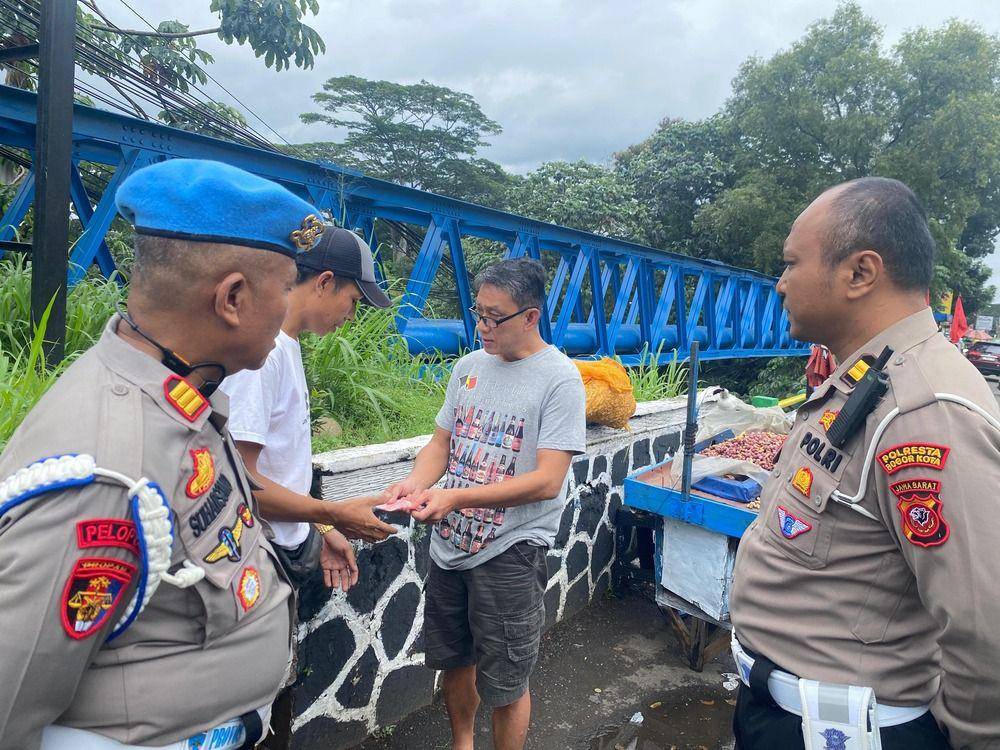 Pengendara mobil pajero memberi ganti rugi ke pedagang kacang karena menabrak gerobak dagangannya hingga kacang berhamburan, Rabu (29/1/2025). (Polresta Bogor Kota).