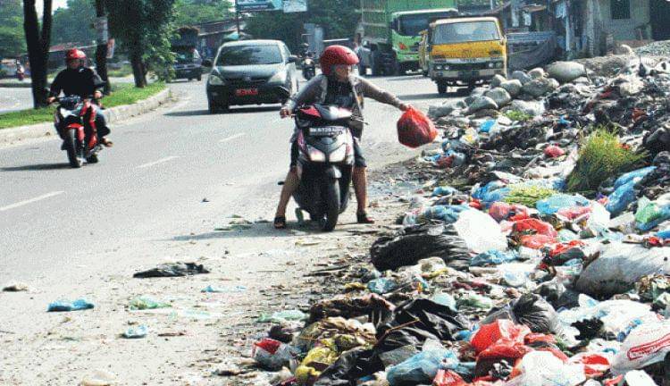 Seseorang yang sedang buang sampah sembarangan (riauaktual.com)