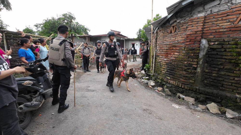 Aparat kepolisian menggunakan anjing pelacak saat penggerebekan di kampung rawan narkoba di Lombok Tengah. (dok. Istimewa)