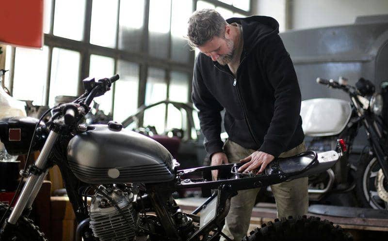 ilustrasi seorang pria sedang memasang komponen PnP untuk modifikasi motornya (pexels.com/Andrea Piacquadio)