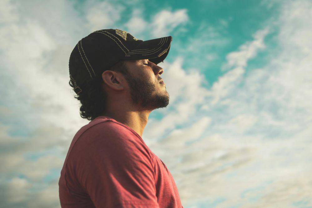 pria mengenakan topi hitam dibawah langit berawan (pexels.com/Kelvin Valerio)