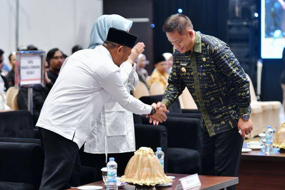 Pj Gubernur Sulawesi Selatan, Fadjry Djufry, memberi selamat kepada Gubernur terpilih Andi Sudirman Sulaiman dalam rapat pleno penetapan, di Hotel Claro, Makassar, Rabu (5/2/2025). (Dok. Humas Pemprov Sulsel)