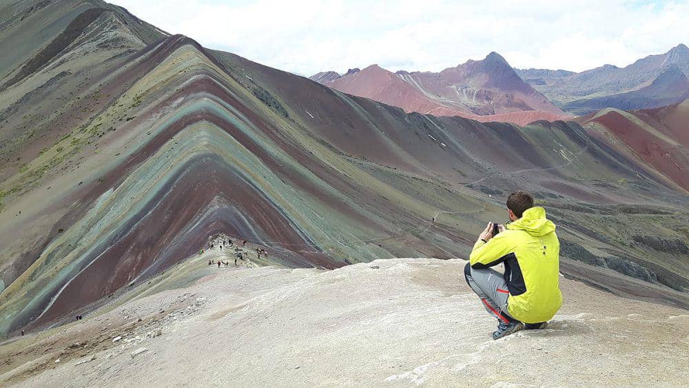 Seorang wisatawan sedang mengambil foto di Vinicunca. (commons.wikimedia.org/Christian Morales Callo)