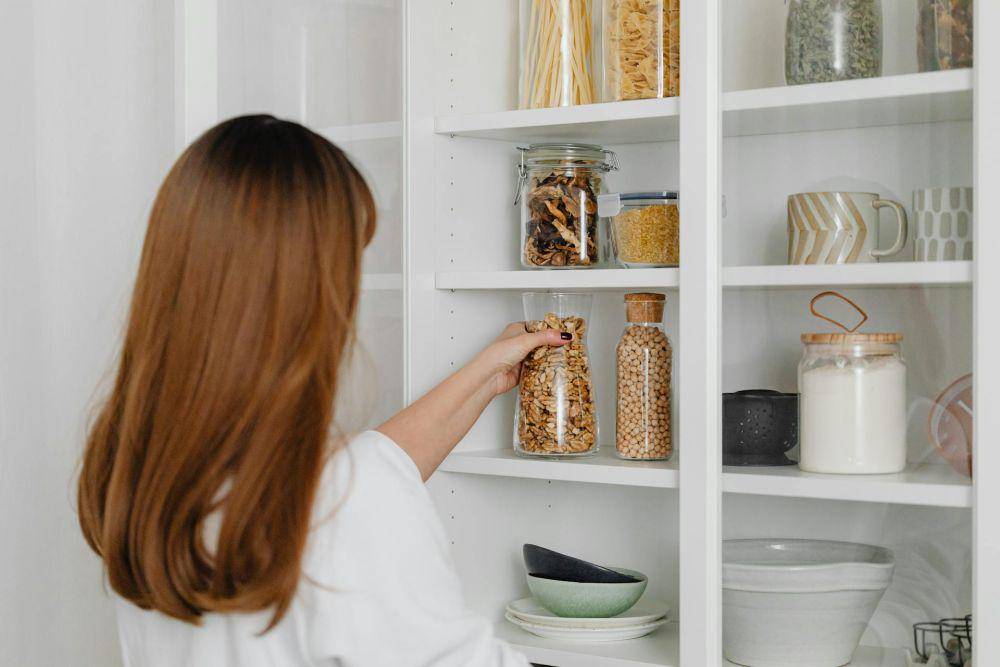 ilustrasi wanita menyimpan makanan di toples (pexels.com/Photo By: Kaboompics.com)