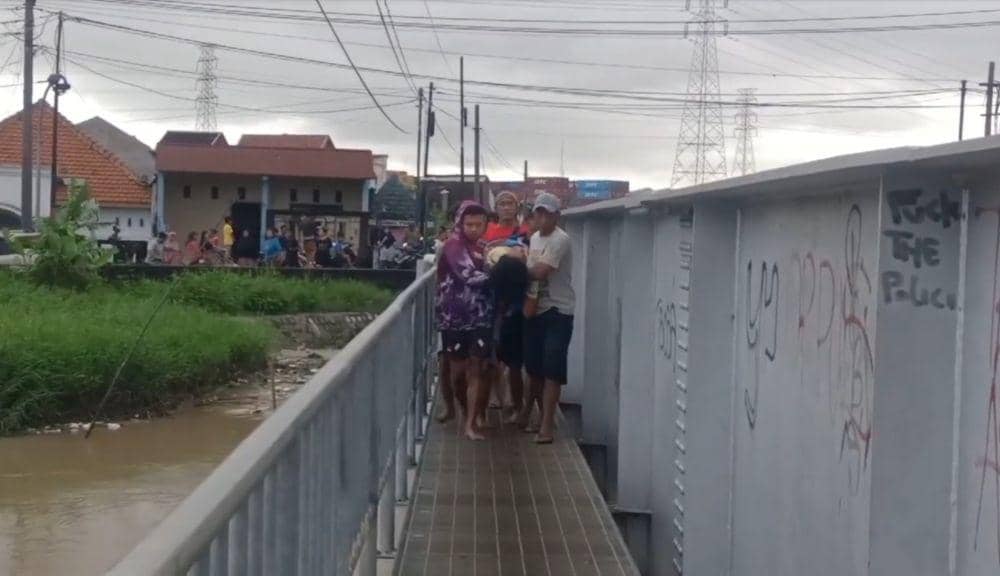 Misiyem digotong beramai-ramai lewati jembatan kecil Sungai BKT. (IDN Times/bt)