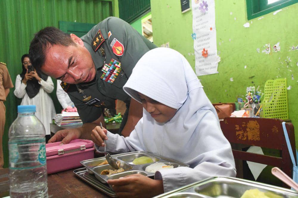 Pangdam Diponegoro Semarang Mayjen Deddy Suryadi melihat cara makan siswi SD yang ikut MBG. (IDN Times/Dok Pendam IV Diponegoro Semarang)
