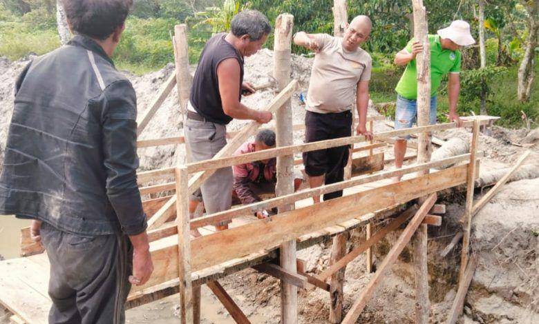 Bhabinkamtibmas Desa Unjur Kecamatan Simanindo, Samosir, membangun jembatan kayu di lokasi di rumah Darma yang viral karena dikelilingi parit usai digali salah satu kerabatnya (dok. Humas Polres Samosir)