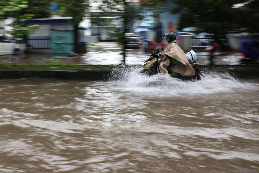 Pengendara motor menerobos banjir di Makassar, Sulawesi Selatan, Selasa (11/2/2025). (ANTARA FOTO/Arnas Padda)