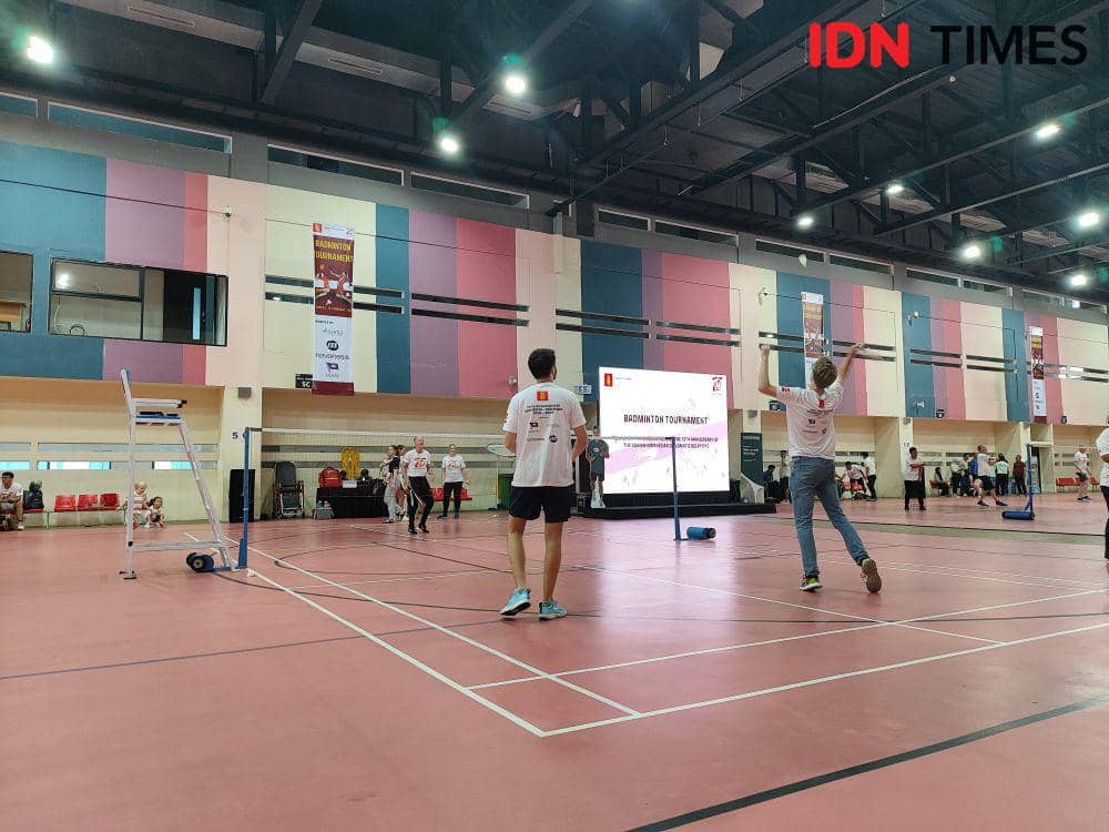 Para pemain turnamen badminton Peringatan 75 Tahun Hubungan Diplomatik Indonesia-Denmark melakukan pemanasan. (IDN Times/Evan Yulian Philaret)