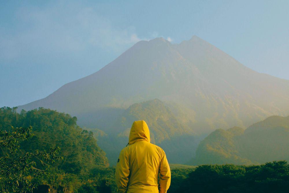 Foto Pria sedang Melihat Gunung Merapi. (Unsplash.com/Moch irsan Shidqi)