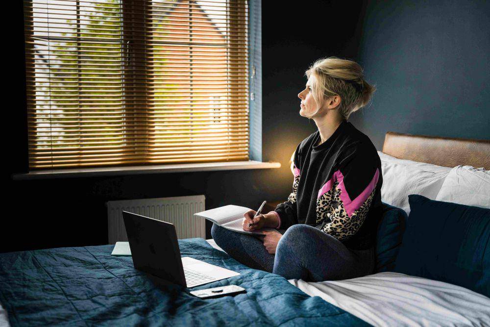 potret seorang wanita sedang merenung di atas kasur (unsplash.com/Jodie Cook)