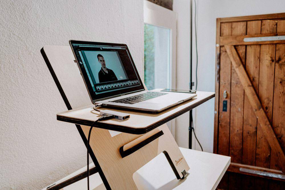 Ilustrasi laptop dengan dudukan  meja kayu (unsplash.com/Standsome Worklifestyle)