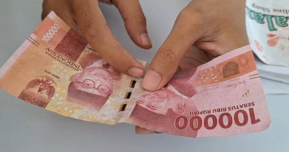 Nilhal Muna Assofiyah, penjaga Outlet Es Teh Pesona, menunjukkan uang palsu. IDN Times/Riyanto.