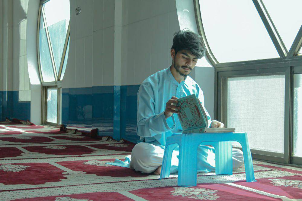 ilustrasi seorang sedang membaca Al-Qur'an (unsplash.com/Syed Aoun Abbas)