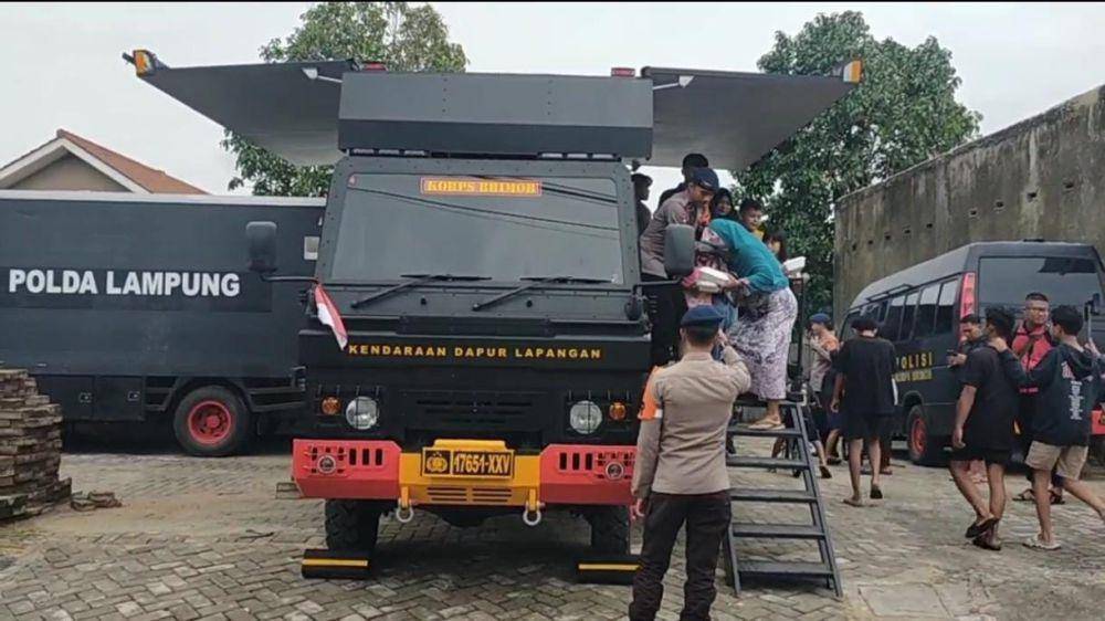Brimob Polda Lampung saat sedang membagikan makanan kepada warga terdampak banjir di Bandar Lampung. (IDN Times/Muhaimin)