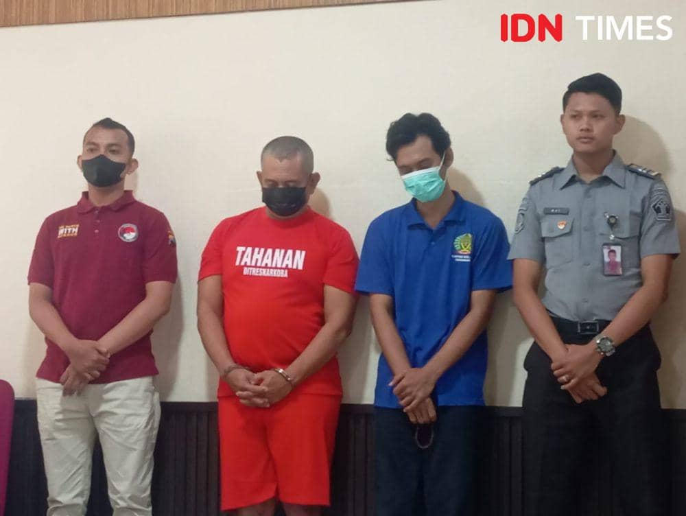 Hery memakai baju biru tertunduk lesu saat diamankan bersama seorang napi kenalannya. (IDN Times/Fariz Fardianto)