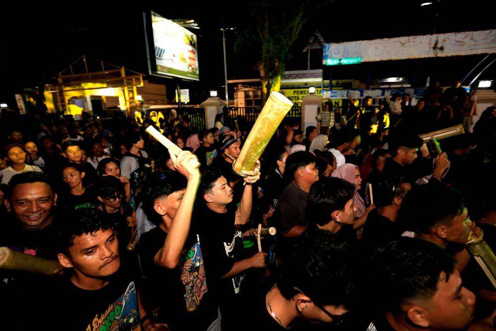 Warga memukul pentungan dan alat musik polo palo yang terbuat dari bambu saat tradisi Koko O atau ketuk sahur di Kota Gorontalo, Gorontalo, Sabtu (1/3/2025). ANTARA FOTO/Adiwinata Solihin
