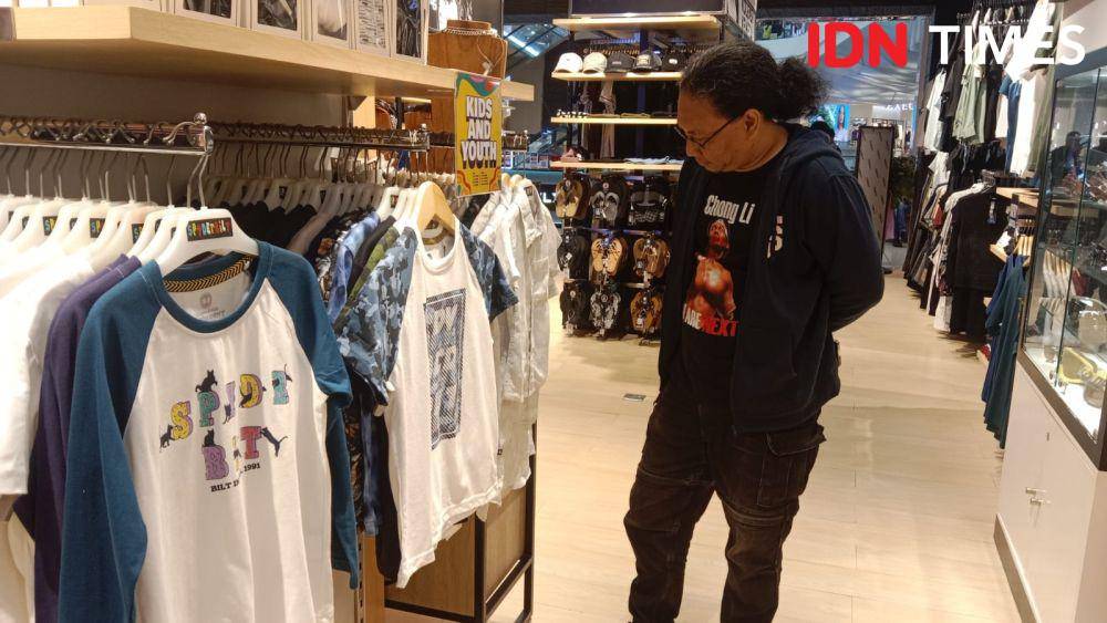 Seorang wartawan saat melihat-lihat pakaian merek terbaru di Planet Surf Paragon Semarang. (IDN Times/Fariz Fardianto)