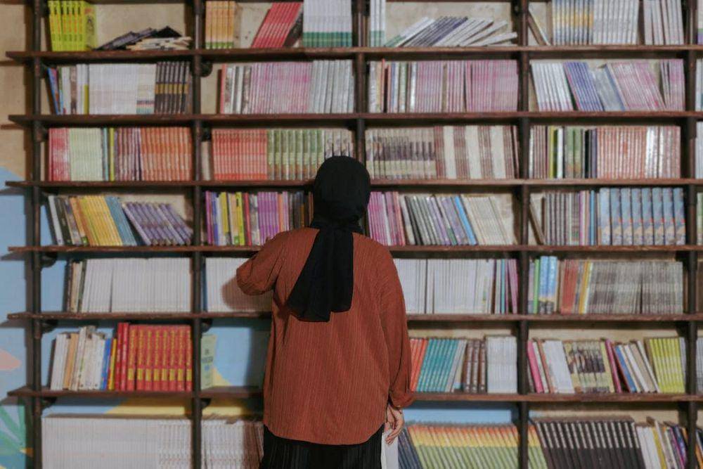 ilustrasi orang memilih buku (pexels.com/Yazid N)