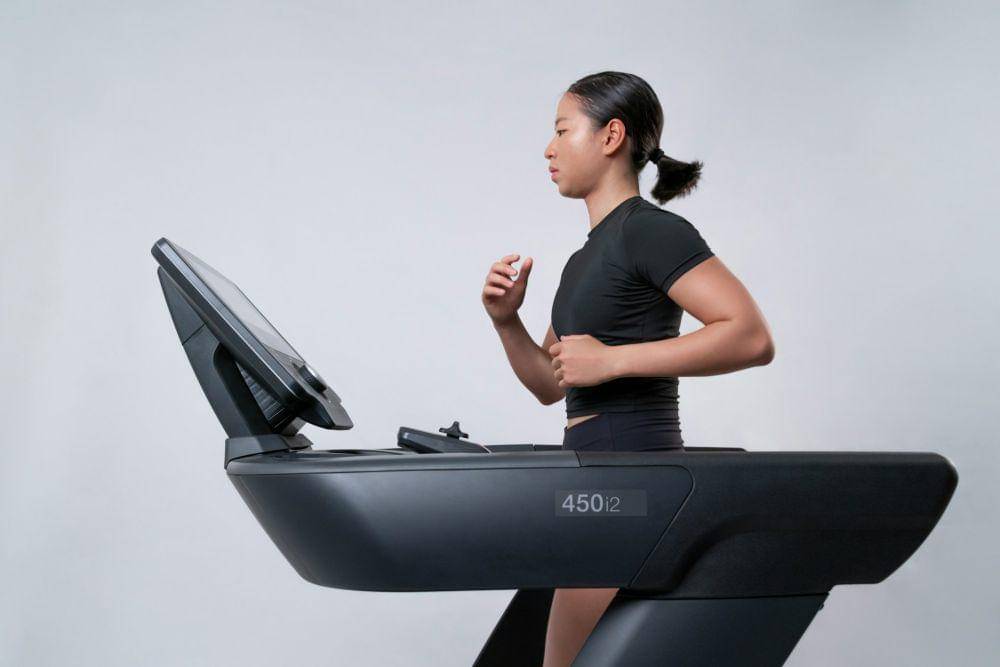 Seorang perempuan berlari di atas treadmill.