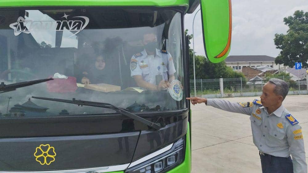 Pemasangan stiker untuk bus yang layak jalan di Terminal Rajabasa. (IDN Times/Muhaimin)