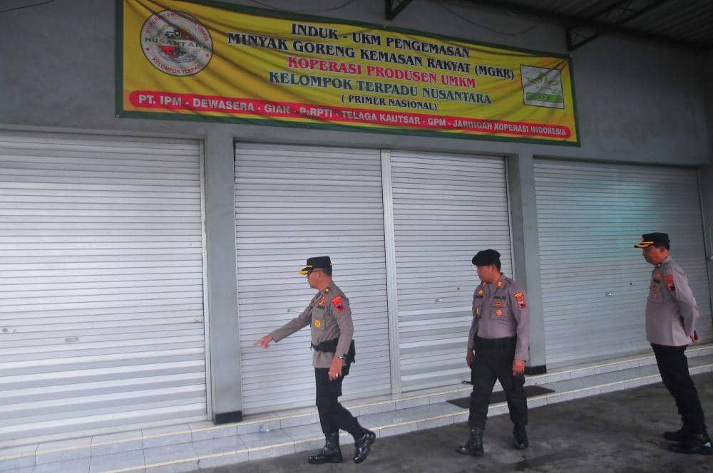Anggota polisi menunjukkan lokasi Koperasi Produsen UMKM Kelompok Terpadu Nusantara yang menjadi tempat pengemasan Minyak Goreng Kemasan Rakyat (MGKR) di Jalan Jendral Soedirman, Golantepus, Mejobo, Kudus, Jawa Tengah, Senin (10/3/2025). (ANTARA FOTO/Yusuf Nugroho)