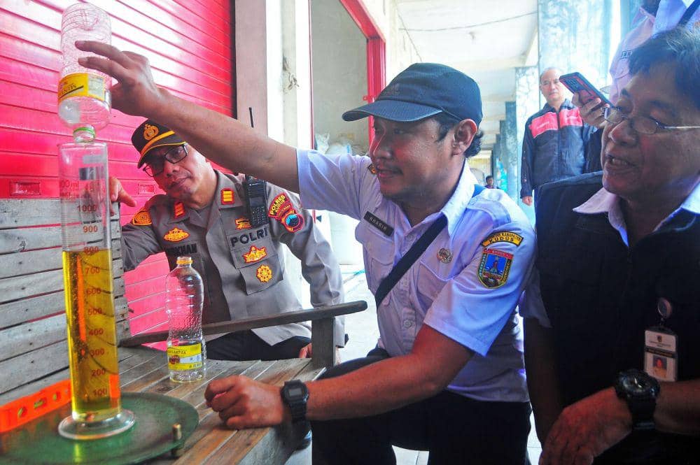 Petugas menakar volume minyak goreng bermerek dagang Minyakita palsu saat sidak di Pasar Baru, Wergu Kulon, Kudus, Jawa Tengah, Rabu (12/3/2025). (ANTARA FOTO/Yusuf Nugroho)