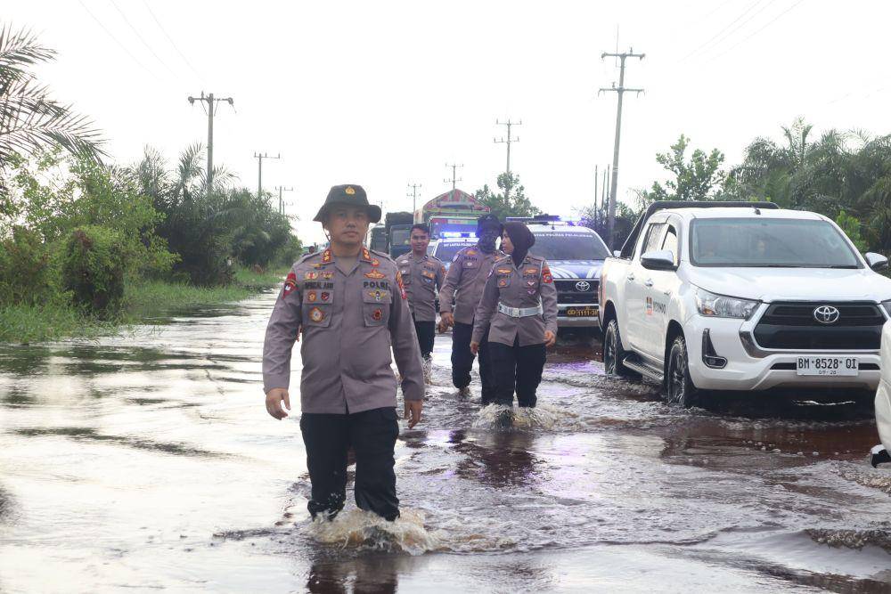 Pihak kepolisian saat mengatur lalu lintas di Jalan Lintas Timur yang dilanda banjir (IDN Times/ dok Polsek Pangkalan Kerinci)