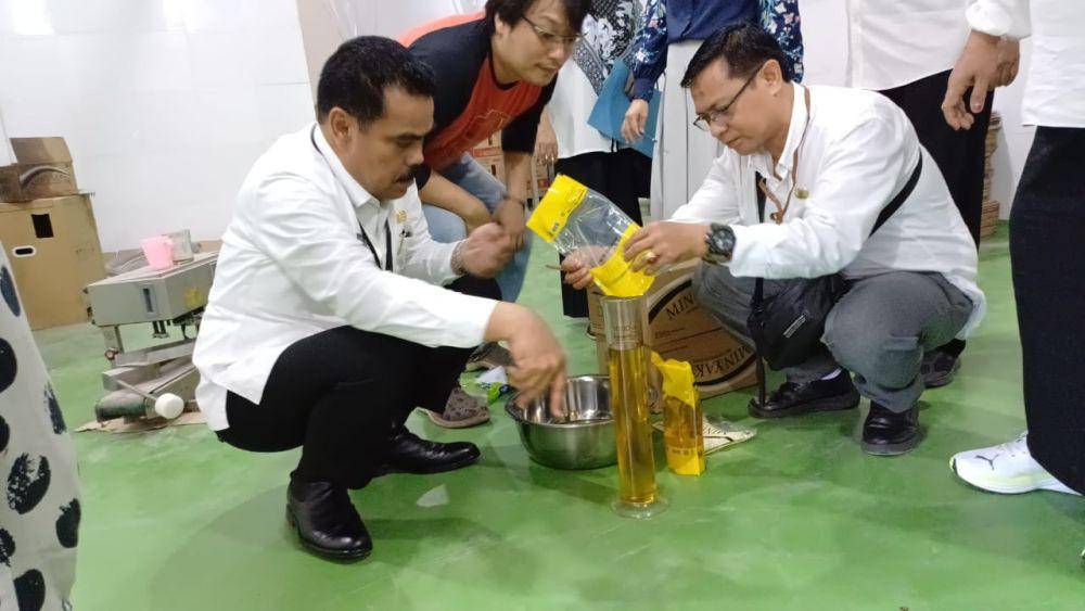 Kepala Dinas Perindustrian dan Perdagangan Sulsel, Ahmadi Akil (kiri), saat mengecek minyak goreng Minyakita di lokasi distributor, Rabu (12/3/2025). (Dok. Disperindag Sulsel)