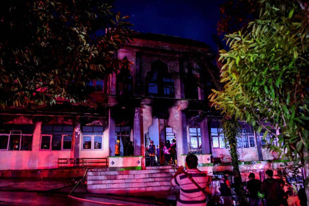 Sejumlah petugas pemadam kebakaran melakukan pembasahan saat terjadinya kebakaran di pondok Pesantren Nabil Husein di Samarinda, Kalimantan Timur, Rabu (12/3/2025). ANTARA FOTO/M Risyal Hidayat/foc.