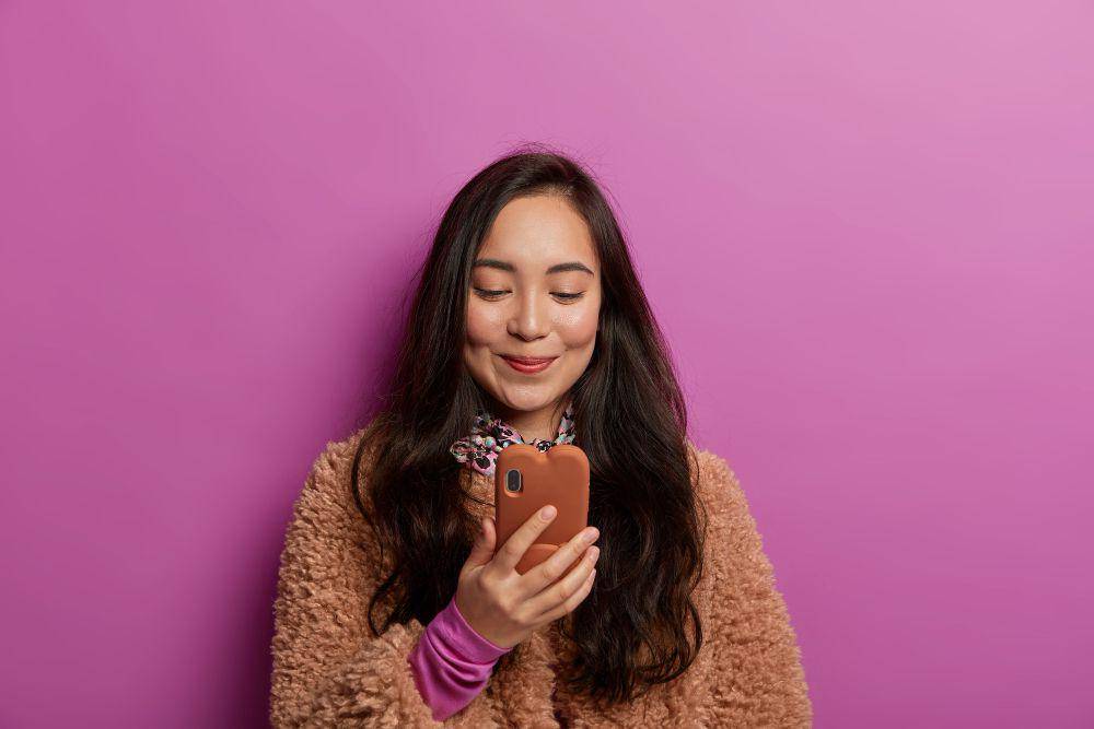 Ilustrasi perempuan membaca sesuatu di HP. (Freepik / wayhomestudio)