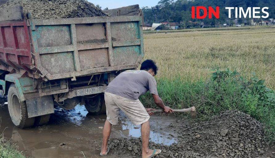 Salah satu warga di dusun Muncu yang sedang bergotong royong memperbaiki jalan rusak walau sedang berpuasa, Sabtu (15/3/2025).(IDN Times/Cokie Sutrisno)