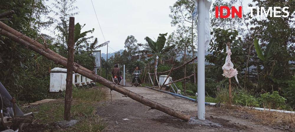 Warga yang hendak melintas di jalan yang rusak terpaksa harus berhati hati,Sabtu (15/3/2025).(IDN Times/Cokie Sutrisno)