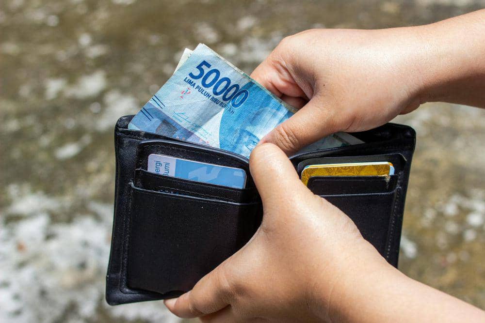 ilustrasi seseorang mengambil uang dalam dompet