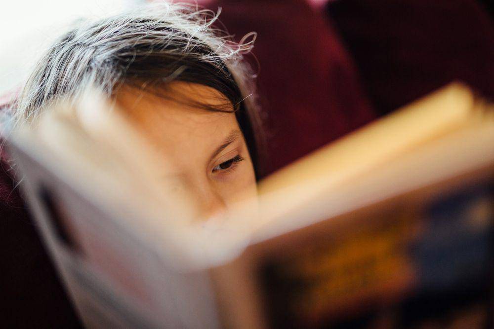 Ilustrasi seorang anak membaca buku. (unsplash.com/Johnny McClung)