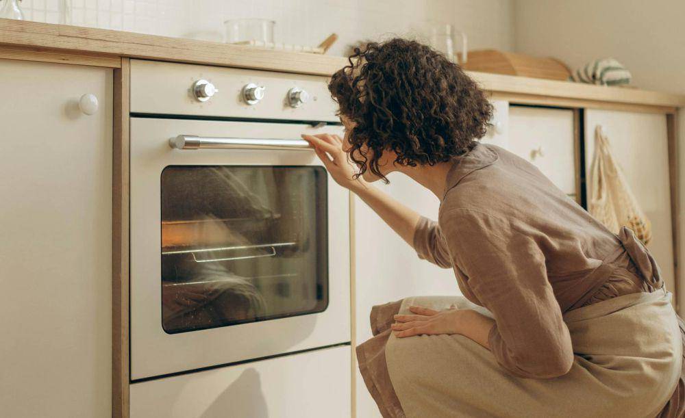 ilustrasi wanita yang mencium aroma harum dari oven (pexels.com/Ron Lach)