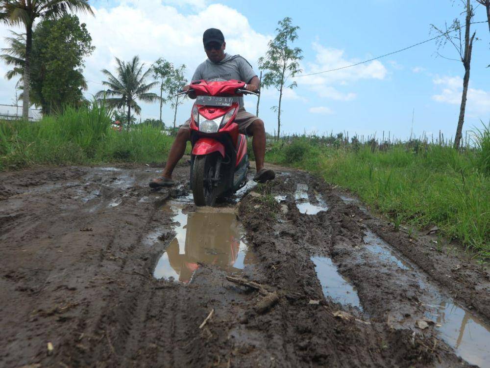 Warga kesulitan melintasi jalan yang mengalami kerusakan parah (IDN Times/Istimewa)