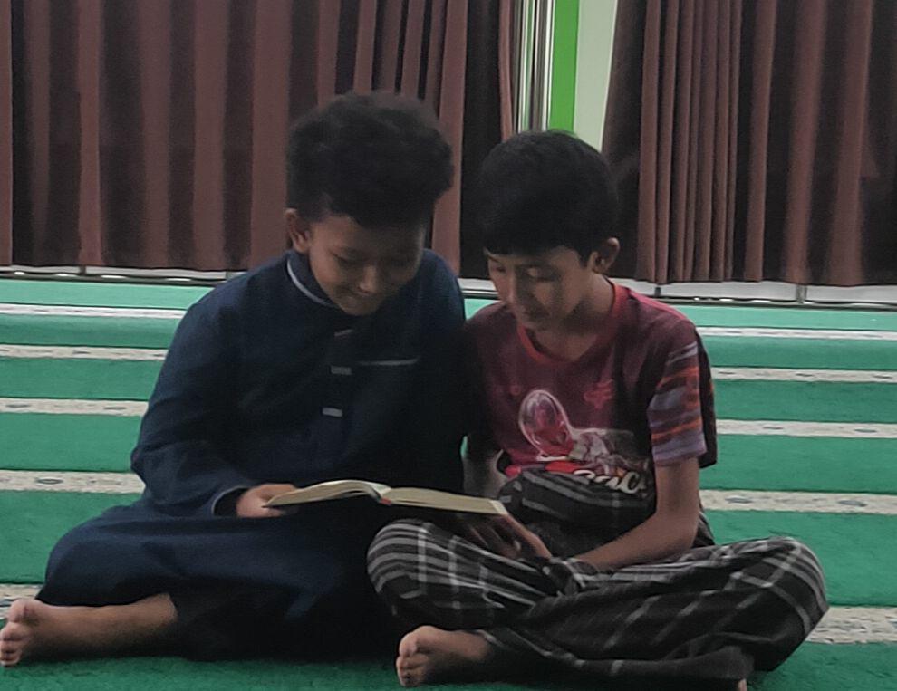 Suasana masjid di mana anak-anak sedang membaca Alquran pada bulan Ramadan