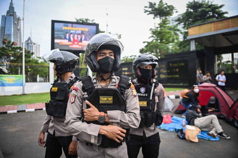 Polisi berjaga di depan pengunjuk rasa yang mendirikan tenda di depan pintu gerbang Pancasila, Gedung DPR RI, Jakarta, Kamis (20/3/2025). (ANTARA FOTO/Bayu Pratama S)