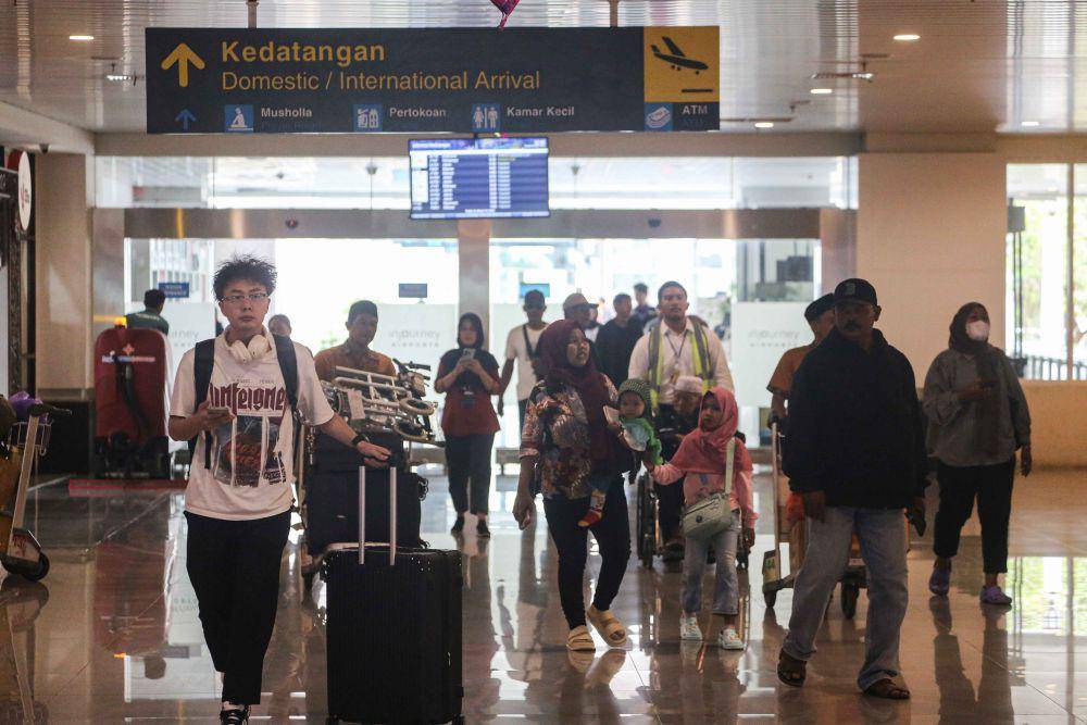 Sejumlah penumpang pesawat berjalan keluar dari terminal kedatangan di Bandara Ahmad Yani, Semarang, Jawa Tengah, Selasa (18/3/2025). (ANTARA FOTO/Makna Zaezar)
