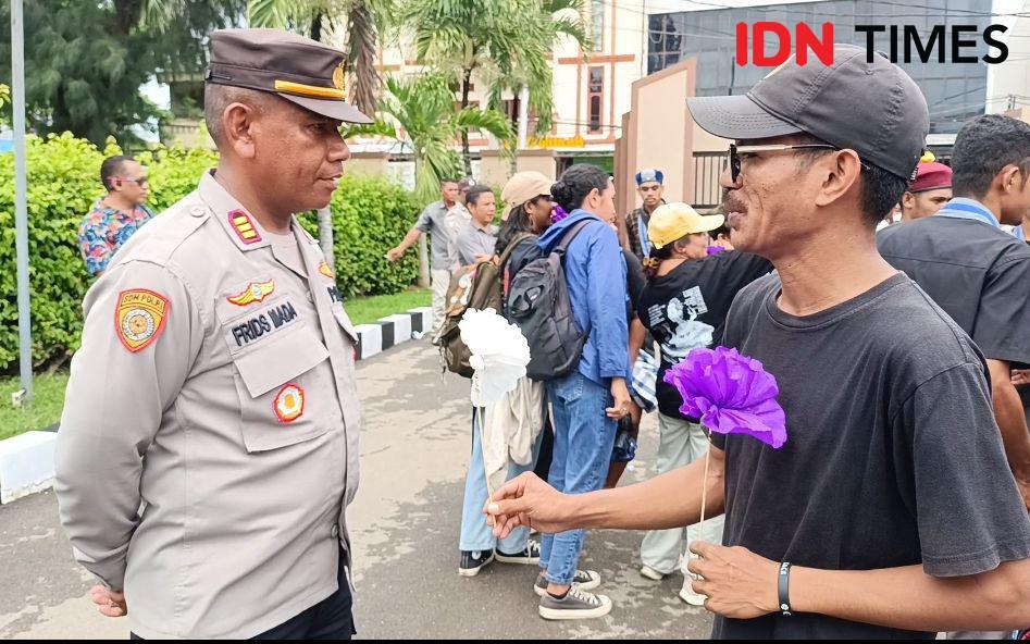 Koalisi Masyarakat Sipil Melawan Kekerasan Seksual Anak membagi bunga kepada polisi. (IDN Times/ Putra F. D. Bali Mula)