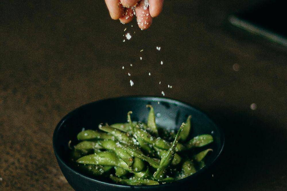Ilustrasi menambahkan garam ke edamame (pexels.com/cottonbro studio)