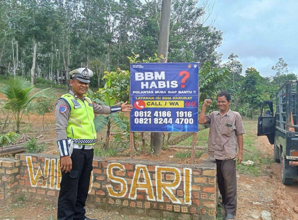 Personil Satlantas Polres Muba saat memasang plang nomor darurat.