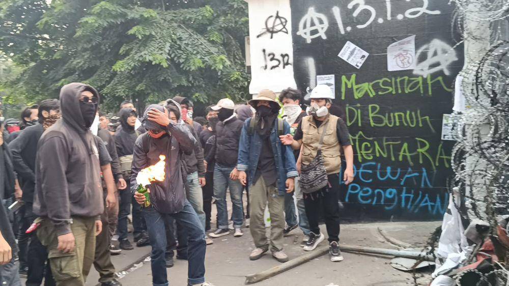 Massa melemparkan bom molotov saat menggelar aksi tolak UU TNI di Kota Bandung, Jumat (21/3/2025). IDN Times/Debbie Sutrisno