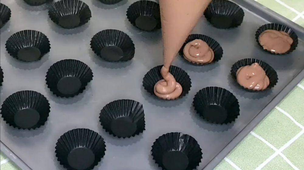 ilustrasi menyemprot adonan brownies ke dalam paper cup mini (YouTube.com/Mama Pin Pan)