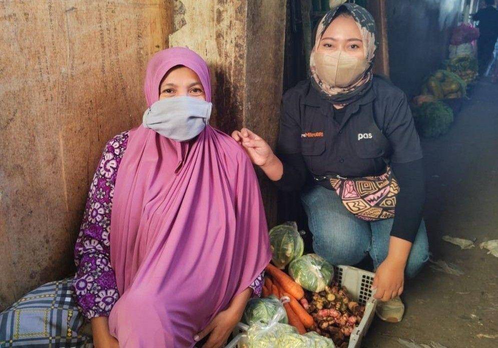 Rika Venisari saat bersama debiturnya di salah satu pasar di Kecamatan Sikur, Kabupaten Lombok Timur. (Dok. Rika Venisari)