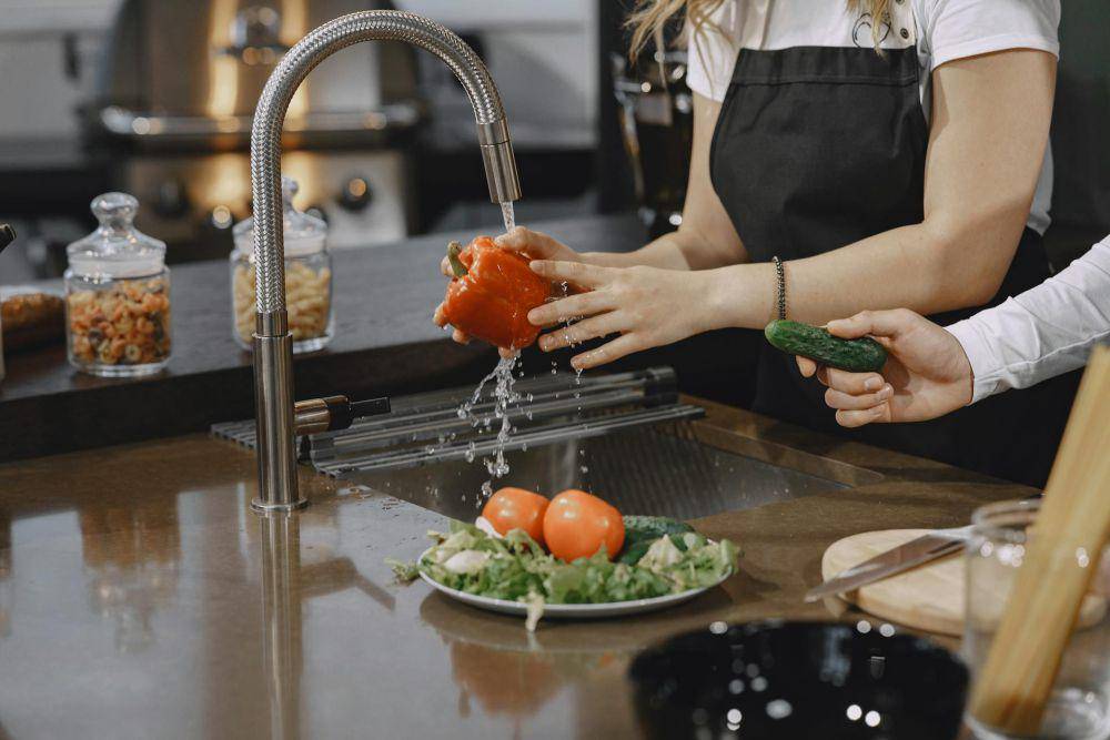 Membersihkan Sayur dengan Air Mengalir