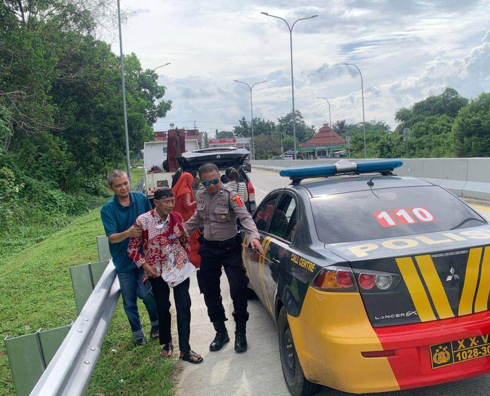 Personel Pos Pengamanan (Pospam) Rest Area 163 A Gunung Batin, Polres Lampung Tengah membantu Sumardi (87), seorang pemudik ke Pospam 163 A Gunung Batin. (Dok. Polres Lamteng).