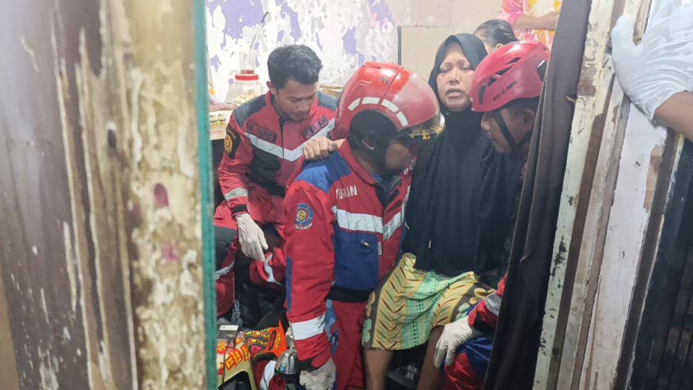 Tim Damkar Makassar evakuasi seorang ibu yang menderita stroke, Selasa (1/4/2025). Dok. IDN Times/Istimewa